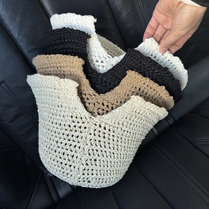 Detail of hollow hand-crocheted sun hats in beige, black and khaki colors