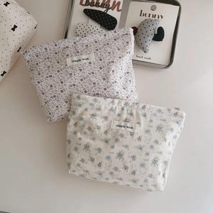 Close-up of small floral cotton makeup bags with simple wish label and zipper detail