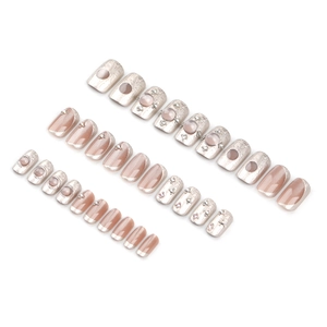 Cat eye press-on nails with silver relief and pink rhinestones set on white background