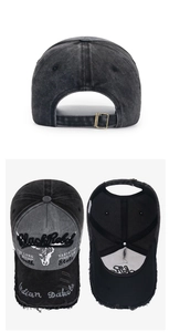 Detail view of washed gray cotton baseball cap featuring Black Rebel embroidery and metal buckle