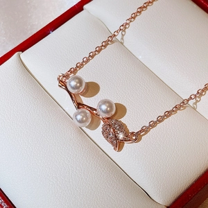 Close-up of rose gold rose petal pendant with white pearls and sparkling zircons