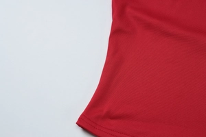 Detailed close-up showing the double-needle stitching on red knitted halter top fabric