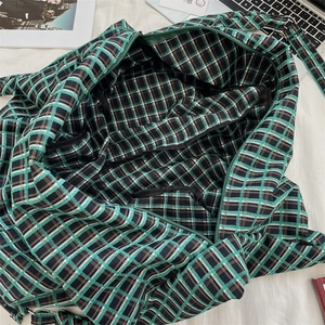 Top-down view of large green checkered tote bag with laptop and lifestyle props