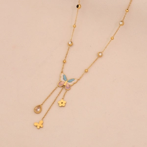 Detail of golden butterfly pendant necklace with colorful enamel and zircon accents
