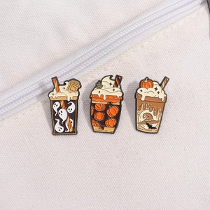 Three Halloween enamel pins featuring ghosts and pumpkins on a beige canvas background