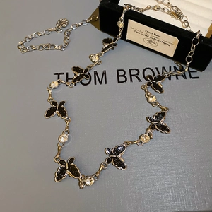 Detailed view of silver butterfly waist chain with rhinestones on a luxury jewelry box