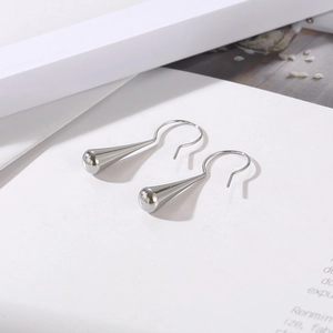 Close-up of elegant silver teardrop earrings with a glossy polished metal finish