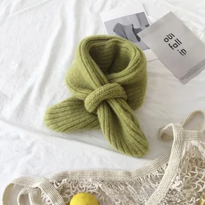 Detail of lime green knit scarf showing thick ribbed texture and crossover knot style