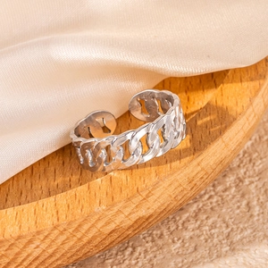 Silver Cuban link open ring on a wooden tray with soft beige silk fabric background
