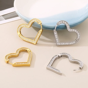 Dettaglio di orecchini a cerchio a cuore oro e argento con zirconi micro-incastonati
