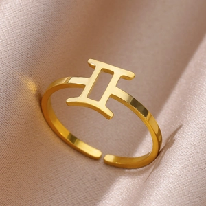 Adjustable golden stainless steel Gemini zodiac sign ring on elegant champagne silk fabric