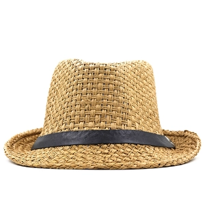 Macro detail of breathable natural straw weave and matte black leather band on fedora