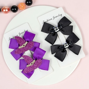 Detail of Halloween hair clips with purple witch hats and black monster bows on display card
