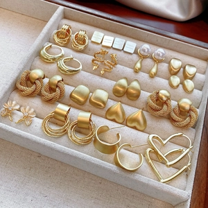 Detailed collection of assorted gold drop earrings with heart and geometric patterns