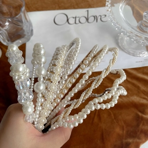 Close-up of elegant pearl and crystal headbands displayed on a velvet background