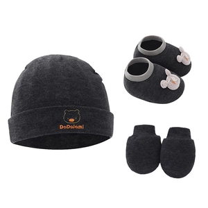 Detailed view of dark grey knitted baby set with hat, shoes, and mittens set