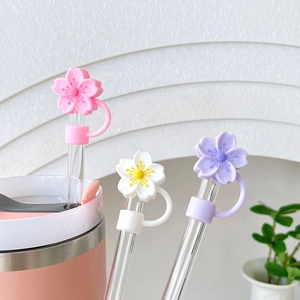 Macro shot of colorful cherry blossom straw covers in pink, white and purple on glass straws