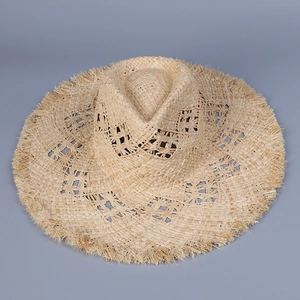 Detail of raffia sun hat with hollow weave pattern and raw fringe edge finish