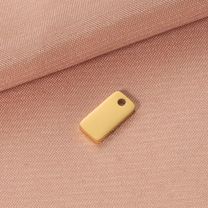 Detailed close-up of a polished gold rectangular metal charm with a pre-drilled hole