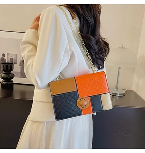Detail of color-block shoulder bag featuring quilted texture and gold metal chain