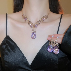 Detail of luxury purple teardrop jewelry set with gold plating and sparkling crystal accents