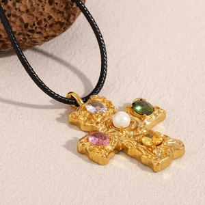 Detail of 18K gold-plated hammered cross pendant with colorful gems and pearl on black cord