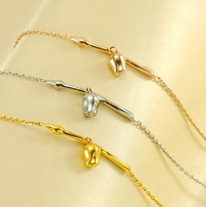 Macro shot of three delicate rose bud bracelets in gold silver and rose gold finishes