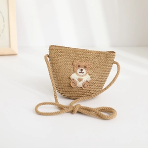 Detail of hand-woven straw crossbody bag for kids featuring a cute 3D bear embroidery