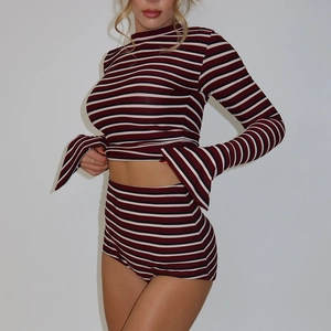 Detail of slim-fit striped two-piece set featuring long sleeves and high waist shorts