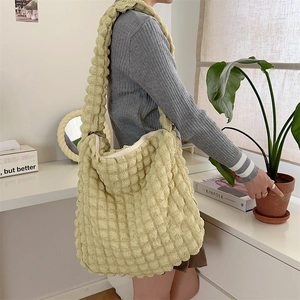 Close-up of light green bubble textured fabric and comfortable wide shoulder strap on tote