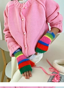 Détail de gants sans doigts en peluche arc-en-ciel avec texture douce et chauffe-poignets