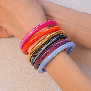 Bracelets géométriques en acrylique coloré avec effet marbré portés en superposition