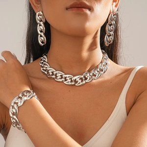 Detailed view of large polished silver curb chain necklace and matching jewelry set