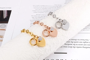 Detailed view of heart pendants in gold, rose gold, and silver finishes with crystal accents