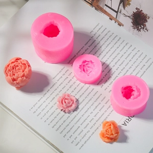Detailopname van roze 3D roos siliconen mallen en afgewerkte bloemen van hars op blad