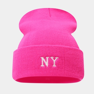 Close-up of pink knitted beanie with white NY embroidery and vertical ribbed texture