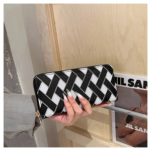 Detail of hand-held long zipper wallet featuring classic black and white woven pattern