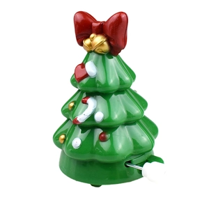Detail of green wind-up walking Christmas tree toy with red bow and gold bells