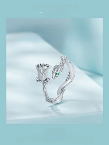 Detailed close-up of 925 sterling silver snake and rose ring with green zircon eyes