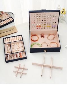Internal layout of navy leather jewelry box with removable tray and ring slots