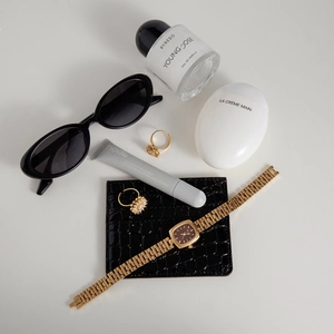 Flat lay of gold flower rings with zircon accents and chic daily accessories