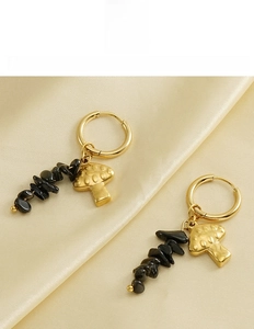 Detail of 18k gold mushroom earrings with black stones on silk background
