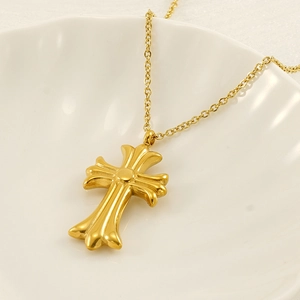 Minimalist gold cross pendant necklace with vintage engraving on a white shell plate