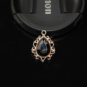 Macro d'un pendentif en pierre noire en forme de larme dans un cadre ornemental en alliage doré
