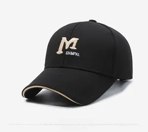 Detail of black baseball cap with beige M embroidery and premium twill cotton texture