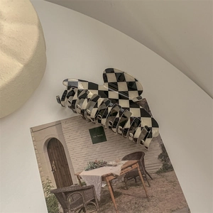 Detail of checkered hair claw clip with black and white pattern on a decorative card