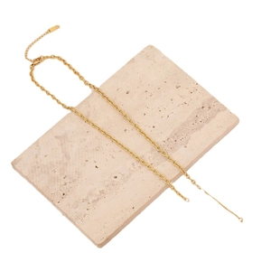 Minimalist gold stainless steel pearl necklace on beige stone with polished chain link