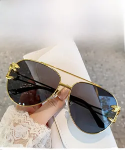 Close-up of golden leopard head hinge detail on pilot sunglasses with gray lenses