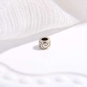 Gros plan d'une perle barillet en argent sterling S925 aux motifs de nuages gravés