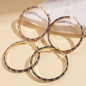 Golden hoop earrings with brown houndstooth and black-white fabric textures